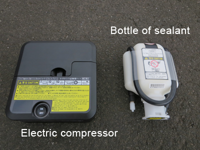Photo 1 shows contents of an emergency repair kit. There are an electric compressor on the left side and a bottle of sealant on the right side.