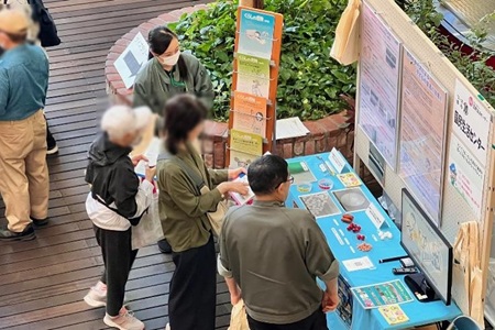 映像や掲示物を交え、注意喚起の内容を来場者に説明している写真