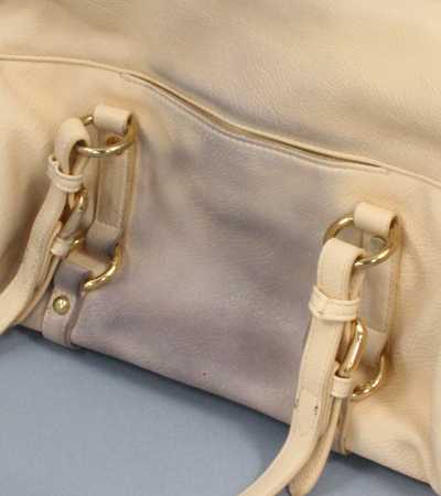 The pale pink bag has a black stain on the central surface.