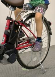 Photo of a child aged 5 seated on the carrier without a child seat and a dress guard. The photo shows that the child's legs are hanged down naturally.