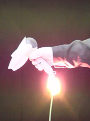Photo of a hair dryer held by a hand, which is generating big sparks from the root of its cord