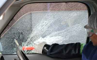 Driver's door glass made of tempered glass was broken into smaller pieces with an emergency escape hammer.