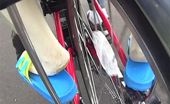 5〜6歳相当のダミー人形の左足かかと部分が自転車の後車輪のすぐ近くにある状態